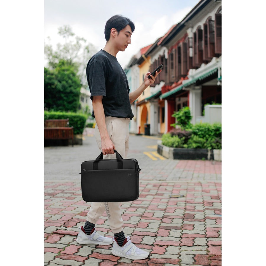 A man confidently walking with the Dell EcoLoop Pro 16" Notebook Carrying Case, demonstrating its functionality and sleek design in a vibrant street atmosphere.