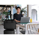 A young professional working on a laptop with the Dell EcoLoop Pro 16" Notebook Carrying Case beside them, illustrating its compatibility and convenience in a café setting.