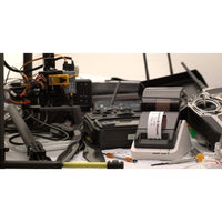 Dynamic setup with the Seiko 203 DPI Smart Label Printer amidst technical equipment, highlighting innovation in label printing for professional use.