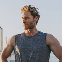 Athletic man wearing Morpheus 360 Spire Wireless Earbuds outdoors, ideal for active lifestyles and workouts.