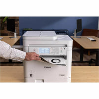 A hand placing a document into the Canon MF289dw Monochrome All-in-One Wireless Laser Printer, showcasing its convenient scanning and copying features.