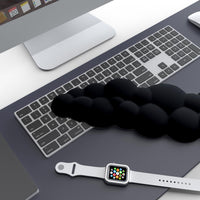 A stylish workstation featuring the CloudWrist Black Memory Foam Wrist Rest by Kokovolta placed next to a keyboard and smartwatch, illustrating the perfect blend of comfort and aesthetics.