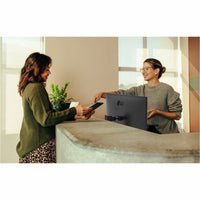 Two professionals interacting by the LG 27BA550B 27" FHD IPS Monitor, showcasing its utility in collaborative office environments.