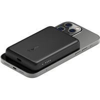 Belkin BoostCharge MagSafe Wireless Power Bank 2500 mAh resting on top of an iPhone, illustrating the magnetic alignment feature for seamless charging without obstructing the camera.